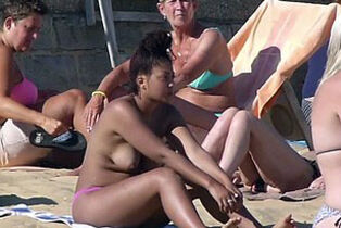 Damsels stripped to the waist on beach